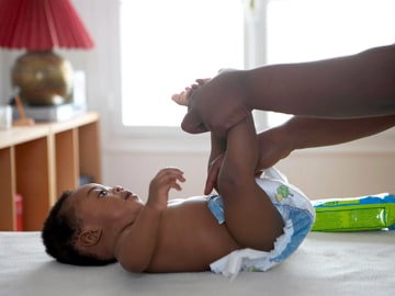 a baby crying while changing his diaper